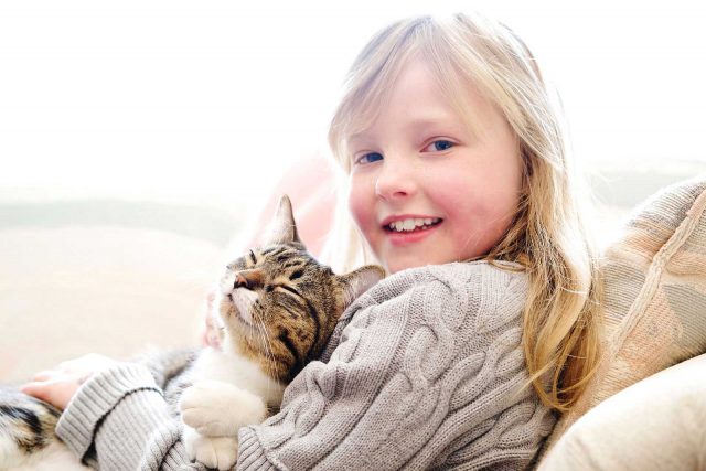 A young girl and her cat, taken by pet photographer Trina Koster at their home.