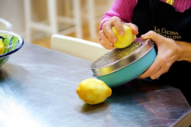 Product photography of a woman preparing lemons for a cookbook recipe.