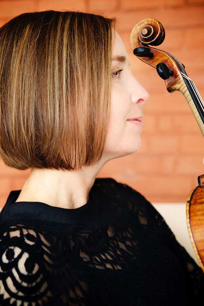 A musician being photographed with her violin by Trina Koster, Guelph.